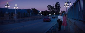 Movie still from “La La Land” (2016), directed by Damien Chazelle – A car driving down a street at night; Wide shot, High angle