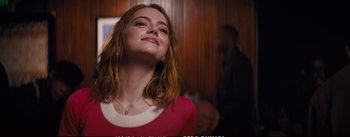 Movie still from “La La Land” (2016), directed by Damien Chazelle – A beautiful young lady with long red hair and wearing a red dress; Close Up shot, Low angle