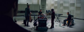 Movie still from “La La Land” (2016), directed by Damien Chazelle – A group of men playing musical instruments in a room; Wide shot, High angle