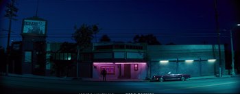 Movie still from “La La Land” (2016), directed by Damien Chazelle – A man standing in front of a building at night; Extreme Wide shot, Low angle