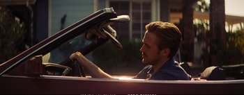 Movie still from “La La Land” (2016), directed by Damien Chazelle – A man sitting in the driver's seat of a car; Close Up shot, Over the shoulder angle