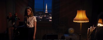 Movie still from “La La Land” (2016), directed by Damien Chazelle – A woman standing in front of a window looking at the eiffel tower at night; Wide shot, Over the shoulder angle