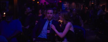 Movie still from “La La Land” (2016), directed by Damien Chazelle – A man and a woman are standing in front of a group of people; Medium shot, Over the shoulder angle