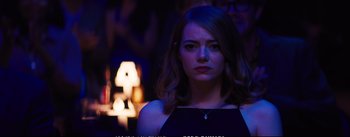 Movie still from “La La Land” (2016), directed by Damien Chazelle – A beautiful young lady standing in front of a lamp; Close Up shot, Over the shoulder angle