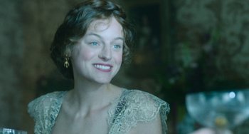 Movie still from “Lady Chatterley's Lover” (2022), directed by Laure de Clermont-Tonnerre – A woman with blue eyes smiling for the camera; Close Up shot, Over the shoulder angle