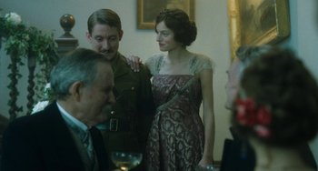 Movie still from “Lady Chatterley's Lover” (2022), directed by Laure de Clermont-Tonnerre – A man and a woman are standing next to each other at a party; Medium shot, Over the shoulder angle