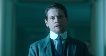 Movie still from “Lady Chatterley's Lover” (2022), directed by Laure de Clermont-Tonnerre – A person wearing a suit and tie; Close Up shot, Low angle