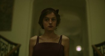 Movie still from “Lady Chatterley's Lover” (2022), directed by Laure de Clermont-Tonnerre – A woman in a red dress is looking at the camera; Close Up shot, Over the shoulder angle