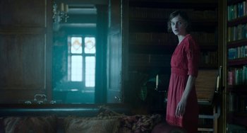 Movie still from “Lady Chatterley's Lover” (2022), directed by Laure de Clermont-Tonnerre – A woman in a red dress standing in front of a window; Medium shot, Low angle