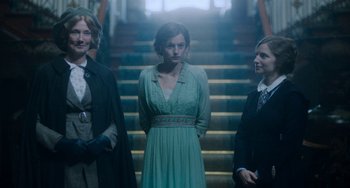 Movie still from “Lady Chatterley's Lover” (2022), directed by Laure de Clermont-Tonnerre – A group of women standing next to each other in front of a staircase; Medium shot, Low angle