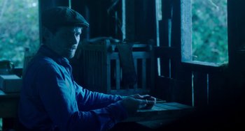 Movie still from “Lady Chatterley's Lover” (2022), directed by Laure de Clermont-Tonnerre – A man sitting in front of a computer keyboard; Medium shot, High angle