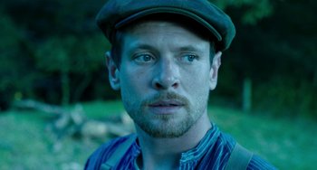 Movie still from “Lady Chatterley's Lover” (2022), directed by Laure de Clermont-Tonnerre – A person wearing a hat; Close Up shot, Low angle
