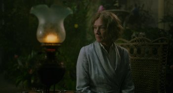 Movie still from “Lady Chatterley's Lover” (2022), directed by Laure de Clermont-Tonnerre – An older woman sitting in front of a lit candle; Medium shot, Over the shoulder angle