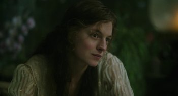 Movie still from “Lady Chatterley's Lover” (2022), directed by Laure de Clermont-Tonnerre – A woman sitting in front of a tree; Close Up shot, Low angle