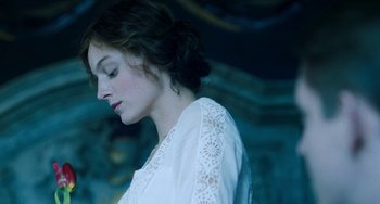 Movie still from “Lady Chatterley's Lover” (2022), directed by Laure de Clermont-Tonnerre – A woman in a white dress is looking down; Close Up shot, Low angle