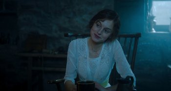 Movie still from “Lady Chatterley's Lover” (2022), directed by Laure de Clermont-Tonnerre – A woman sitting in a chair holding a coffee mug; Medium shot, Over the shoulder angle