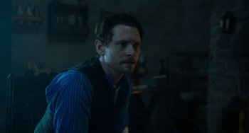 Movie still from “Lady Chatterley's Lover” (2022), directed by Laure de Clermont-Tonnerre – A man in a blue shirt and a black vest; Medium shot, Over the shoulder angle