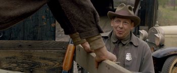 Movie still from “Lawless” (2012), directed by John Hillcoat – An older man wearing a hat is holding the hand of a younger man; Close Up shot, Over the shoulder angle