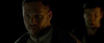 Movie still from “Lawless” (2012), directed by John Hillcoat – A person wearing a suit and tie; Close Up shot, Low angle