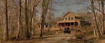 Movie still from “Lawless” (2012), directed by John Hillcoat – An old truck is parked in front of a house; Extreme Wide shot, High angle