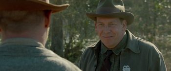 Movie still from “Lawless” (2012), directed by John Hillcoat – A man wearing a hat and a tie; Close Up shot, Over the shoulder angle