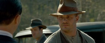 Movie still from “Lawless” (2012), directed by John Hillcoat – A man in a hat and a man in a suit; Close Up shot, Over the shoulder angle