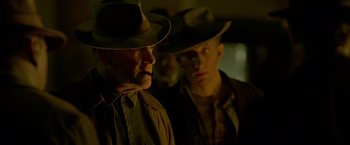 Movie still from “Lawless” (2012), directed by John Hillcoat – Two men wearing hats and one is smoking a cigarette; Close Up shot, Over the shoulder angle