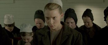 Movie still from “Lawless” (2012), directed by John Hillcoat – A group of people in a room with one woman wearing a hat; Close Up shot, Over the shoulder angle