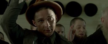 Movie still from “Lawless” (2012), directed by John Hillcoat – A person wearing a hat; Close Up shot, Over the shoulder angle