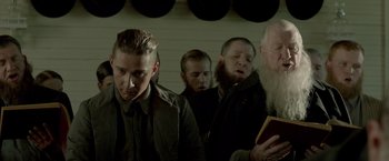Movie still from “Lawless” (2012), directed by John Hillcoat – A group of men standing next to each other in a room; Medium shot, Low angle