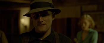 Movie still from “Lawless” (2012), directed by John Hillcoat – A man wearing a hat and a black shirt; Close Up shot, Low angle