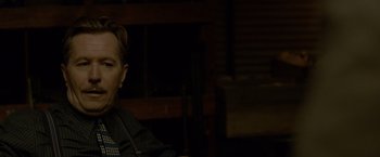 Movie still from “Lawless” (2012), directed by John Hillcoat – A man sitting in front of a wooden wall; Close Up shot, Over the shoulder angle