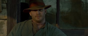 Movie still from “Lawless” (2012), directed by John Hillcoat – A man wearing a brown hat and a brown jacket; Close Up shot, Over the shoulder angle