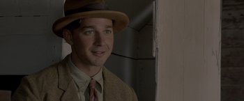 Movie still from “Lawless” (2012), directed by John Hillcoat – A man wearing a hat and a suit; Close Up shot, Over the shoulder angle