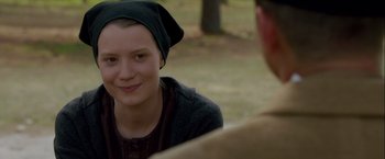 Movie still from “Lawless” (2012), directed by John Hillcoat – A young woman wearing a black hat and a sweater; Close Up shot, Over the shoulder angle