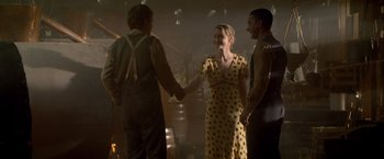 Movie still from “Lawless” (2012), directed by John Hillcoat – Two men and a woman shaking hands in a dimly - lit room; Medium shot, Over the shoulder angle
