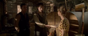 Movie still from “Lawless” (2012), directed by John Hillcoat – A man and a woman shaking hands while another man watches; Medium shot, Over the shoulder angle