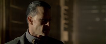 Movie still from “Lawless” (2012), directed by John Hillcoat – A person wearing a suit and tie; Close Up shot, Over the shoulder angle