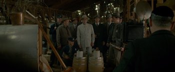 Movie still from “Lawless” (2012), directed by John Hillcoat – A group of men standing next to each other in front of barrels; Wide shot, High angle