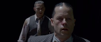Movie still from “Lawless” (2012), directed by John Hillcoat – Two men in suits and ties are looking at the camera; Close Up shot, Over the shoulder angle