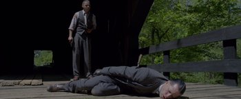 Movie still from “Lawless” (2012), directed by John Hillcoat – A man laying on the ground next to another man; Wide shot, High angle