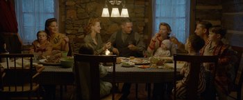 Movie still from “Lawless” (2012), directed by John Hillcoat – A group of people sitting around a table eating food; Wide shot, High angle