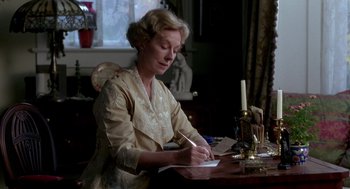 Movie still from “Legends of the Fall” (1994), directed by Edward Zwick – An older woman writing on a piece of paper at a table; Medium shot, Low angle