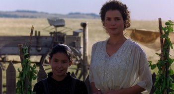 Movie still from “Legends of the Fall” (1994), directed by Edward Zwick – A woman standing next to a young girl in a field; Medium shot, Low angle