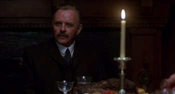 Movie still from “Legends of the Fall” (1994), directed by Edward Zwick – A man sitting at a table with a candle in the dark; Close Up shot, Low angle