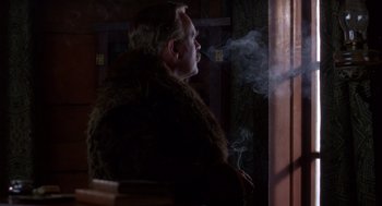 Movie still from “Legends of the Fall” (1994), directed by Edward Zwick – A man wearing a fur coat and smoking a cigarette; Medium shot, Low angle