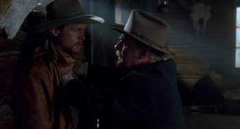 Movie still from “Legends of the Fall” (1994), directed by Edward Zwick – A man in a hat and a man in a jacket and a hat; Close Up shot, Over the shoulder angle