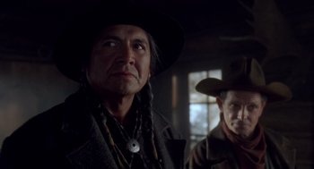 Movie still from “Legends of the Fall” (1994), directed by Edward Zwick – A man in a cowboy hat standing next to another man; Close Up shot, Over the shoulder angle