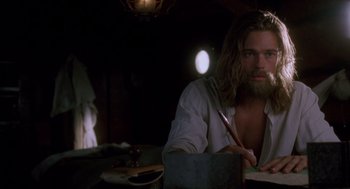 Movie still from “Legends of the Fall” (1994), directed by Edward Zwick – A man sitting at a table writing on a piece of paper; Medium shot, Low angle