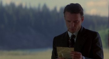 Movie still from “Legends of the Fall” (1994), directed by Edward Zwick – A man wearing a suit and tie looking down at an envelope; Close Up shot, Low angle